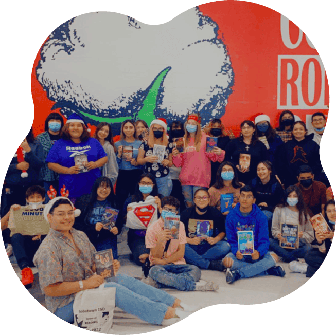 Group of high school students displaying reading challenge rewards including books and tee shirts